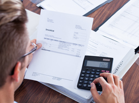 stock-photo-portrait-of-young-businessman-using-calculator-in-office